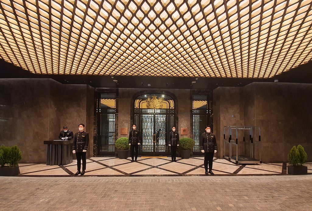 Luxury hotel entrance with distinctive geometric ceiling pattern and uniformed staff